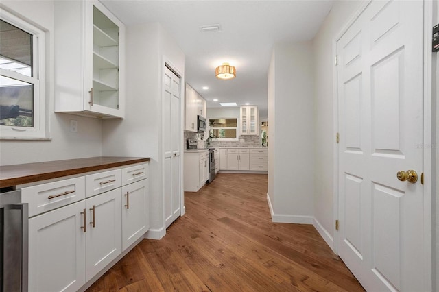 corridor with beverage cooler and light hardwood / wood-style floors