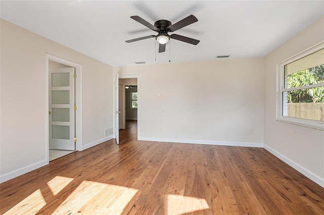 spare room with plenty of natural light, ceiling fan, and light wood-type flooring