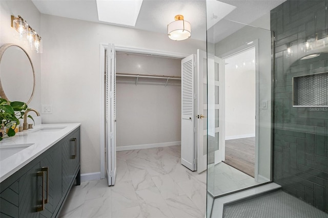 bathroom with a skylight, a shower with door, and vanity