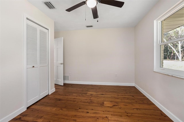 unfurnished bedroom featuring ceiling fan, dark hardwood / wood-style flooring, and a closet