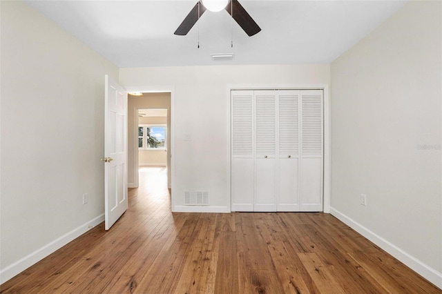 unfurnished bedroom featuring a closet, light hardwood / wood-style flooring, and ceiling fan