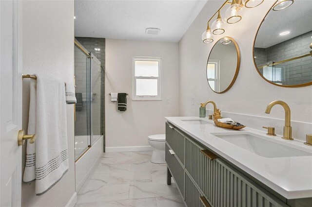 full bathroom featuring vanity, bath / shower combo with glass door, and toilet