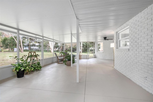 unfurnished sunroom with ceiling fan