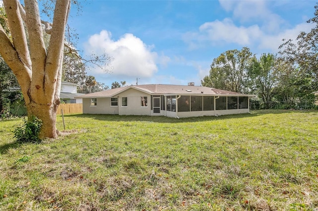 back of property featuring a yard and a sunroom