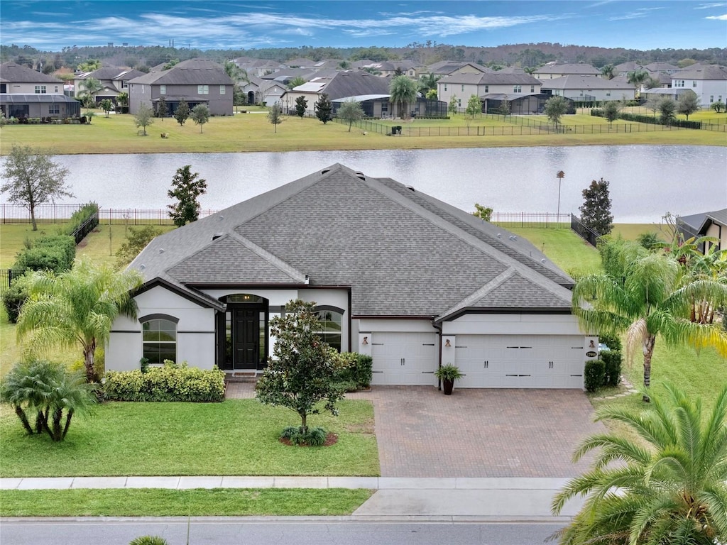 exterior space with a front yard, a garage, and a water view