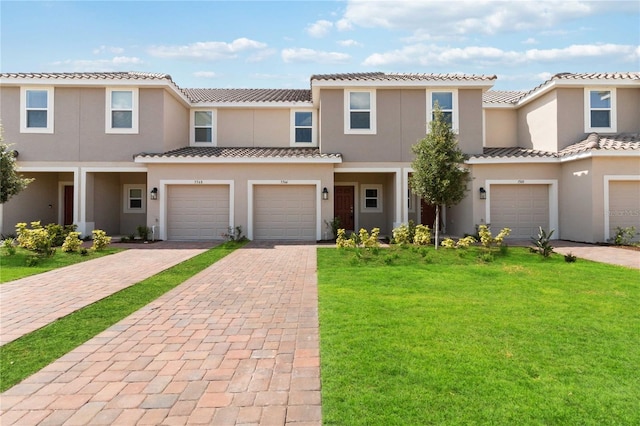 mediterranean / spanish house featuring a garage and a front yard