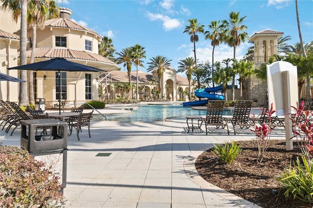 view of swimming pool with a patio area and a water slide