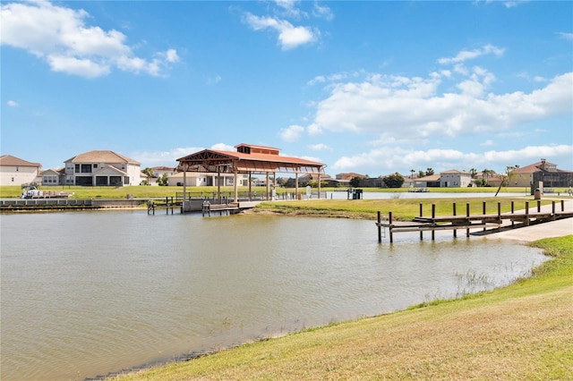 view of dock with a lawn and a water view