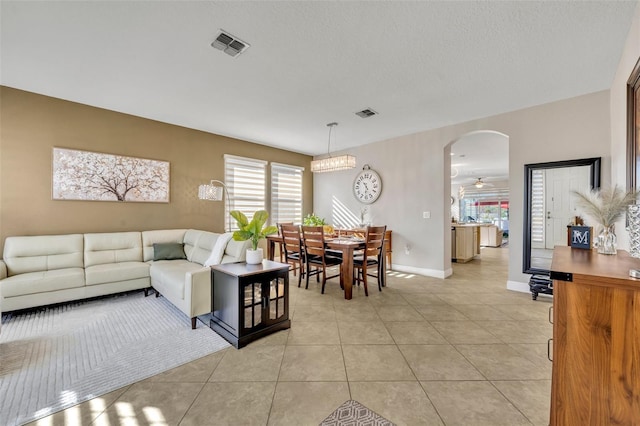 tiled living room featuring a textured ceiling and ceiling fan