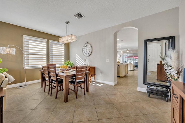 tiled dining space featuring a textured ceiling