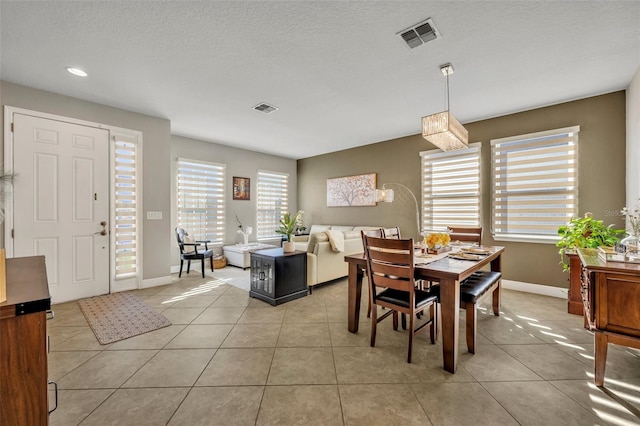 dining room featuring light tile patterned floors and a textured ceiling