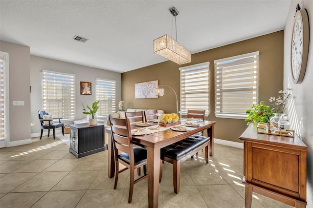 tiled dining space with a textured ceiling