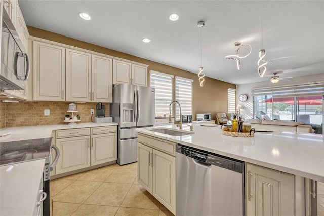 kitchen featuring ceiling fan, sink, pendant lighting, cream cabinetry, and appliances with stainless steel finishes