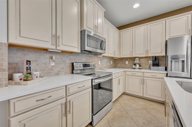 kitchen with light tile patterned floors, appliances with stainless steel finishes, and tasteful backsplash