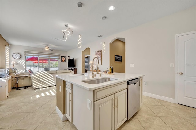 kitchen featuring stainless steel dishwasher, ceiling fan, sink, light tile patterned floors, and a center island with sink