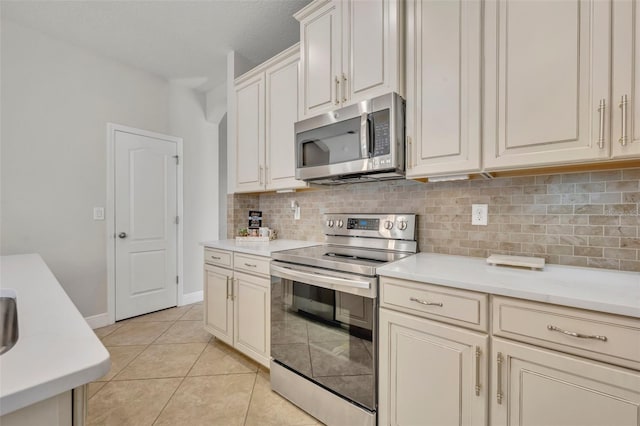 kitchen with light tile patterned floors, stainless steel appliances, and tasteful backsplash