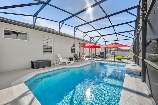 view of swimming pool with glass enclosure and a patio