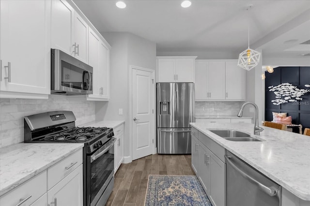 kitchen featuring light stone countertops, sink, white cabinetry, and stainless steel appliances