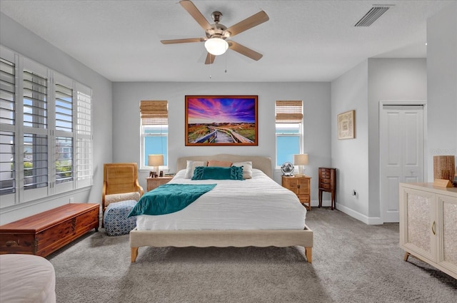 carpeted bedroom with ceiling fan and a closet