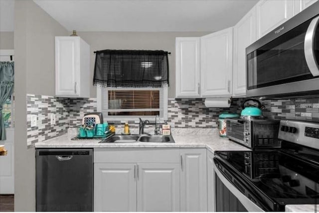 kitchen with decorative backsplash, sink, white cabinets, and appliances with stainless steel finishes