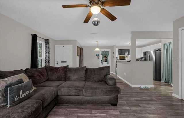 living room with ceiling fan and dark hardwood / wood-style flooring