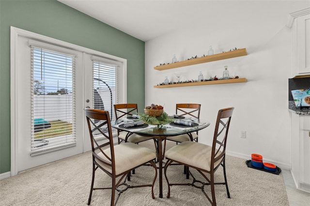 dining space featuring light carpet and french doors