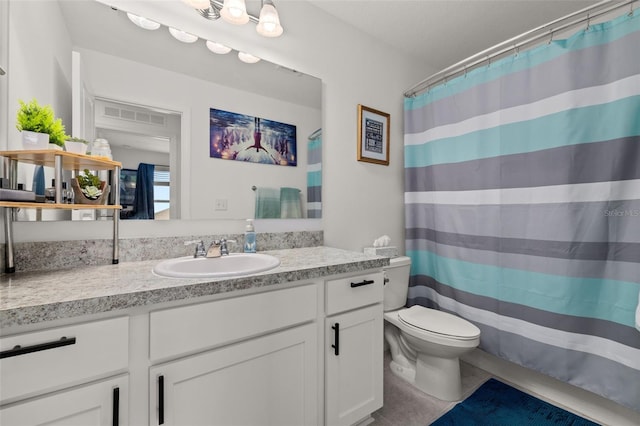 bathroom with tile patterned flooring, vanity, toilet, and walk in shower