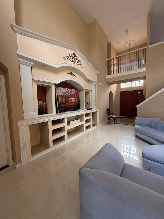 tiled living room with a high ceiling