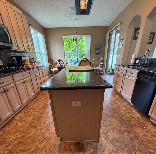 kitchen featuring pendant lighting, dishwasher, a kitchen island, and a textured ceiling