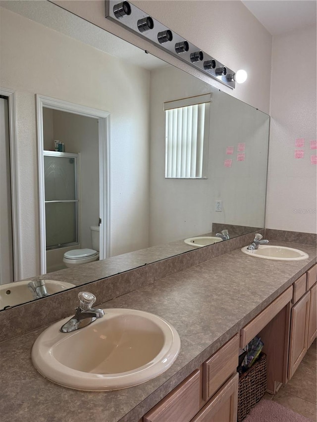 full bathroom featuring tile patterned flooring, vanity, toilet, and bath / shower combo with glass door