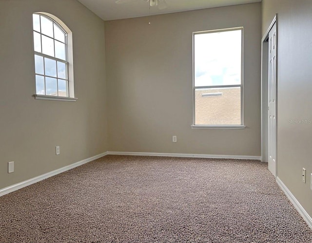 carpeted empty room featuring ceiling fan