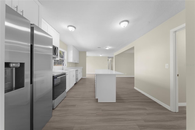 kitchen featuring white cabinets, a center island, dark hardwood / wood-style flooring, stainless steel appliances, and sink