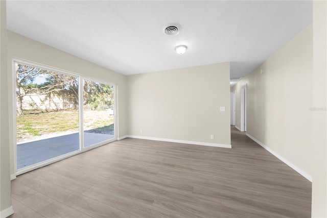 spare room featuring wood-type flooring