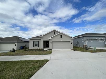 ranch-style home featuring a garage and a front lawn