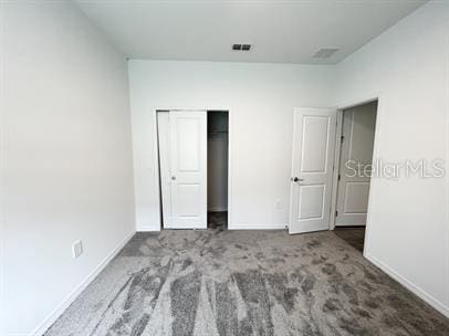 unfurnished bedroom with carpet and a closet