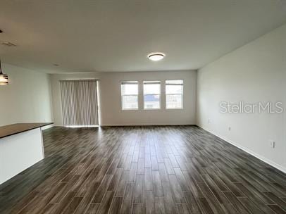 unfurnished living room featuring dark wood-type flooring