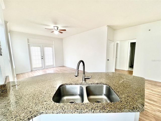 kitchen with stone countertops, ceiling fan, sink, and french doors