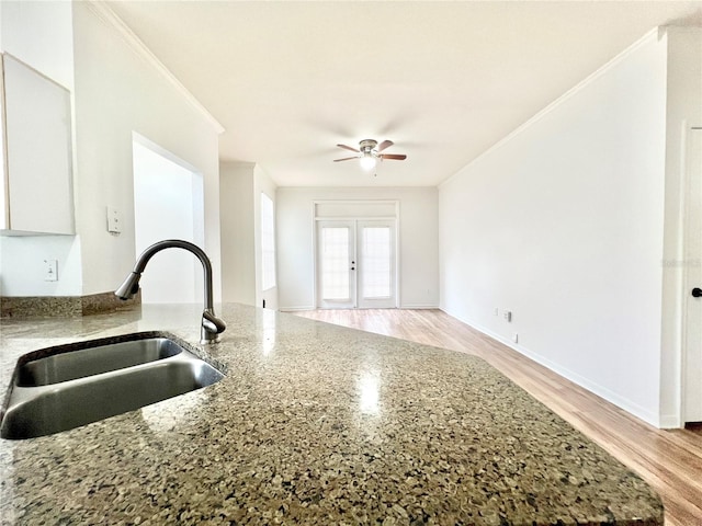 kitchen with ceiling fan, sink, white cabinets, and stone countertops