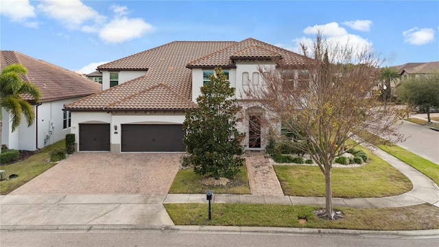 mediterranean / spanish-style home featuring a garage and a front lawn