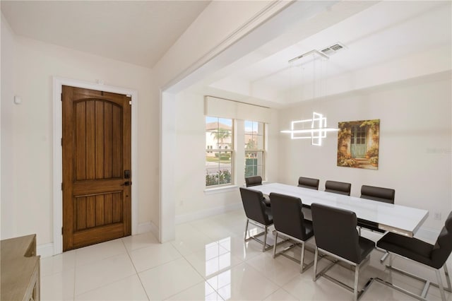 dining area featuring a raised ceiling and light tile patterned floors