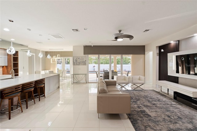 living room featuring sink, ceiling fan, and light tile patterned flooring