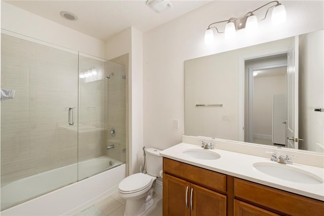 full bathroom featuring tile patterned flooring, vanity, bath / shower combo with glass door, and toilet