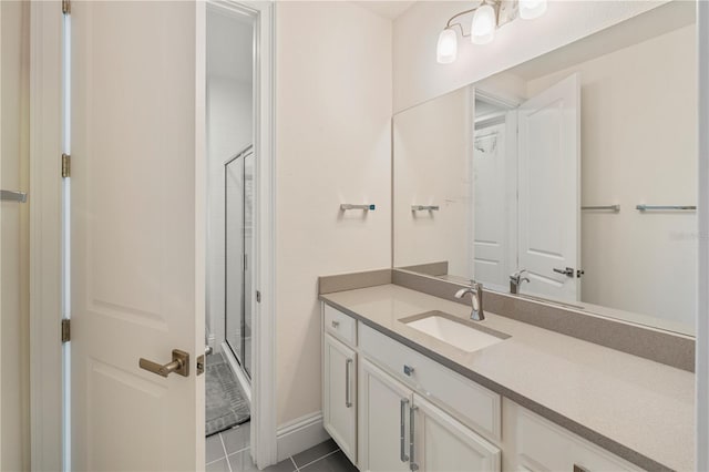 bathroom featuring tile patterned flooring, vanity, and a shower with door