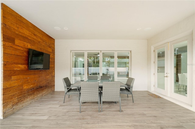 interior space featuring french doors, wooden walls, and light hardwood / wood-style flooring