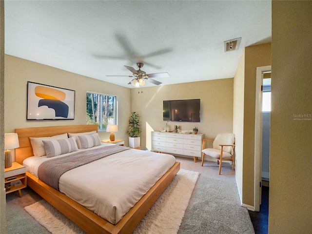 carpeted bedroom with multiple windows and ceiling fan