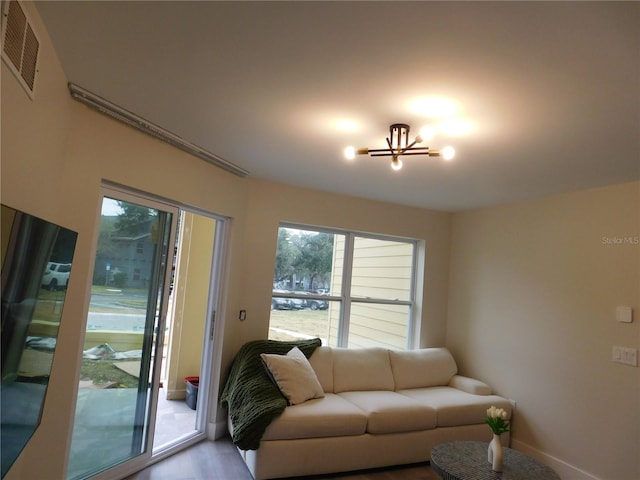 living room featuring hardwood / wood-style floors, plenty of natural light, and a notable chandelier