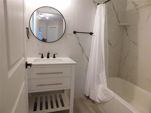 bathroom featuring vanity, shower / bathtub combination with curtain, and tile walls