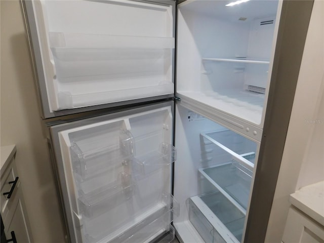 interior details with white fridge and white cabinetry