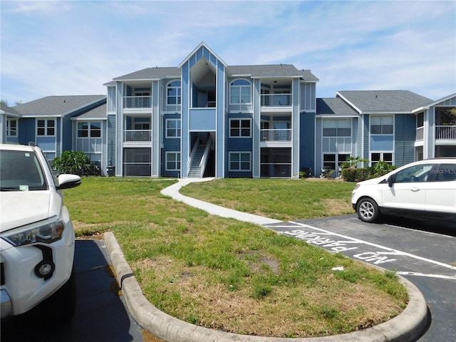view of building exterior featuring a residential view and uncovered parking