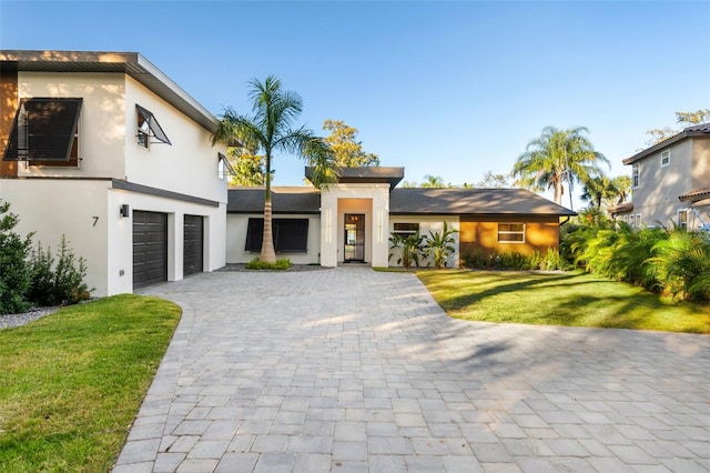 view of front of property featuring a front lawn and a garage